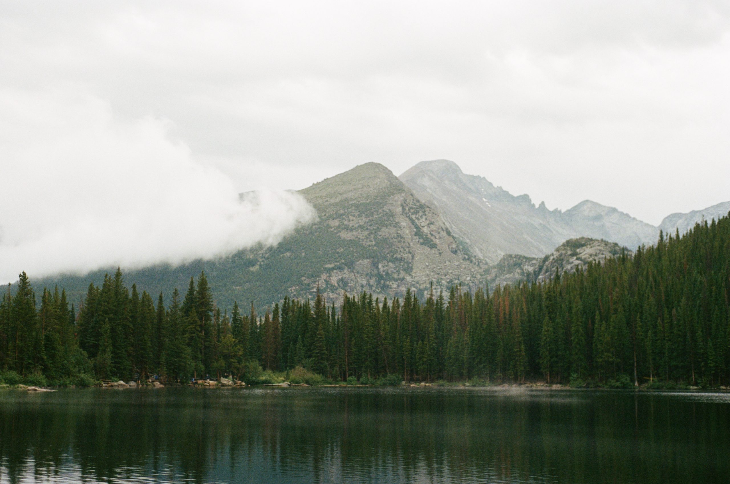 lake in front of forested mountain landscape